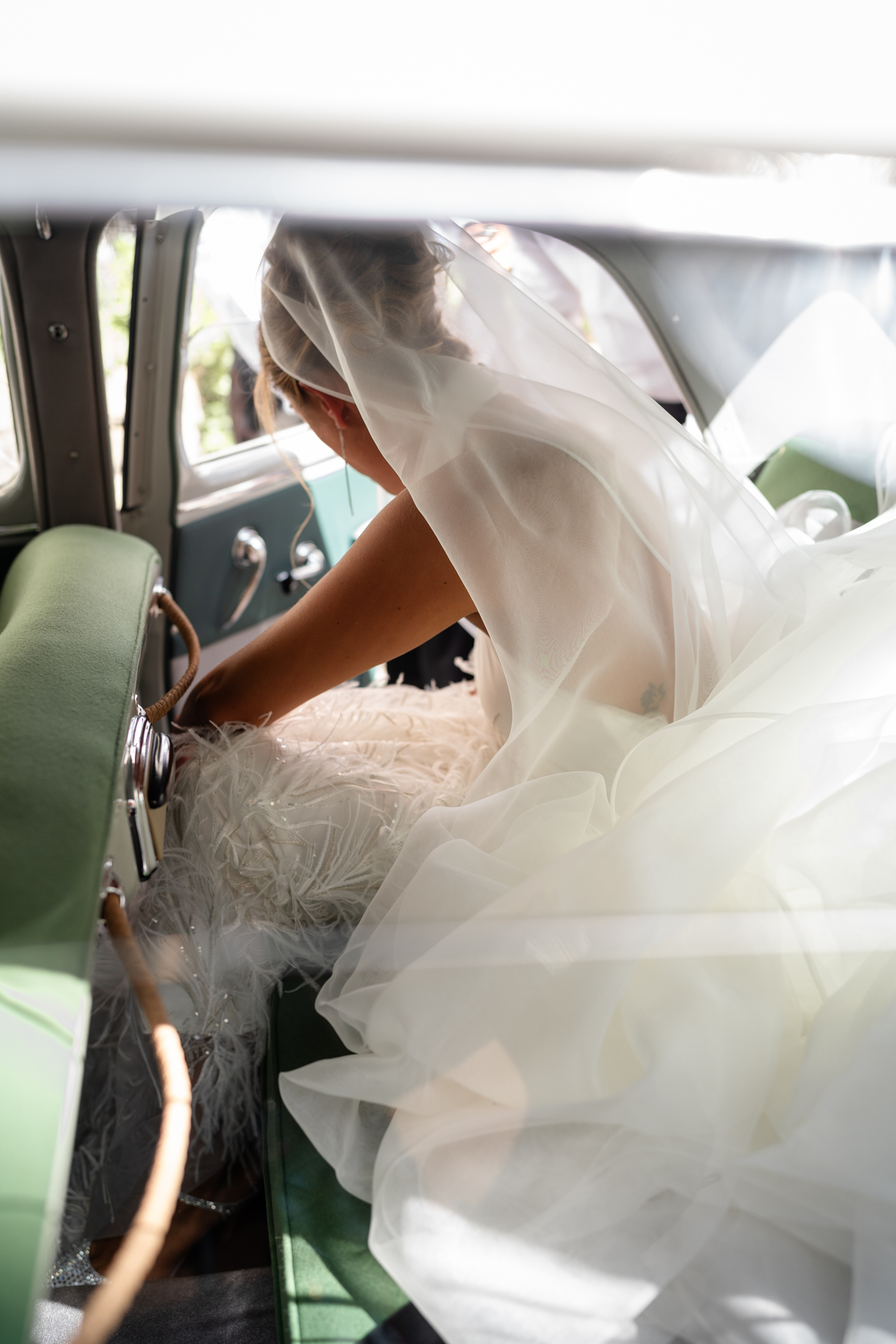 Elegant wedding in Portofino, with a view of the Ligurian bay, celebration at the historic Vesta Portofino by Dolce & Gabbana venue, capturing the atmosphere of the Dolce Vita and the Italian Riviera, bride with bouquet going to the cerimony in a vintage car