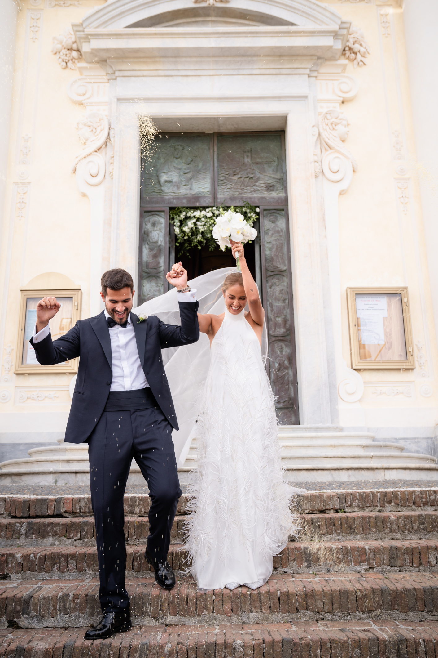 Elegant wedding in Portofino, with a view of the Ligurian bay, celebration at the historic Vesta Portofino by Dolce & Gabbana venue, capturing the atmosphere of the Dolce Vita and the Italian Riviera, cerimony bride and groom outside the churh smiling