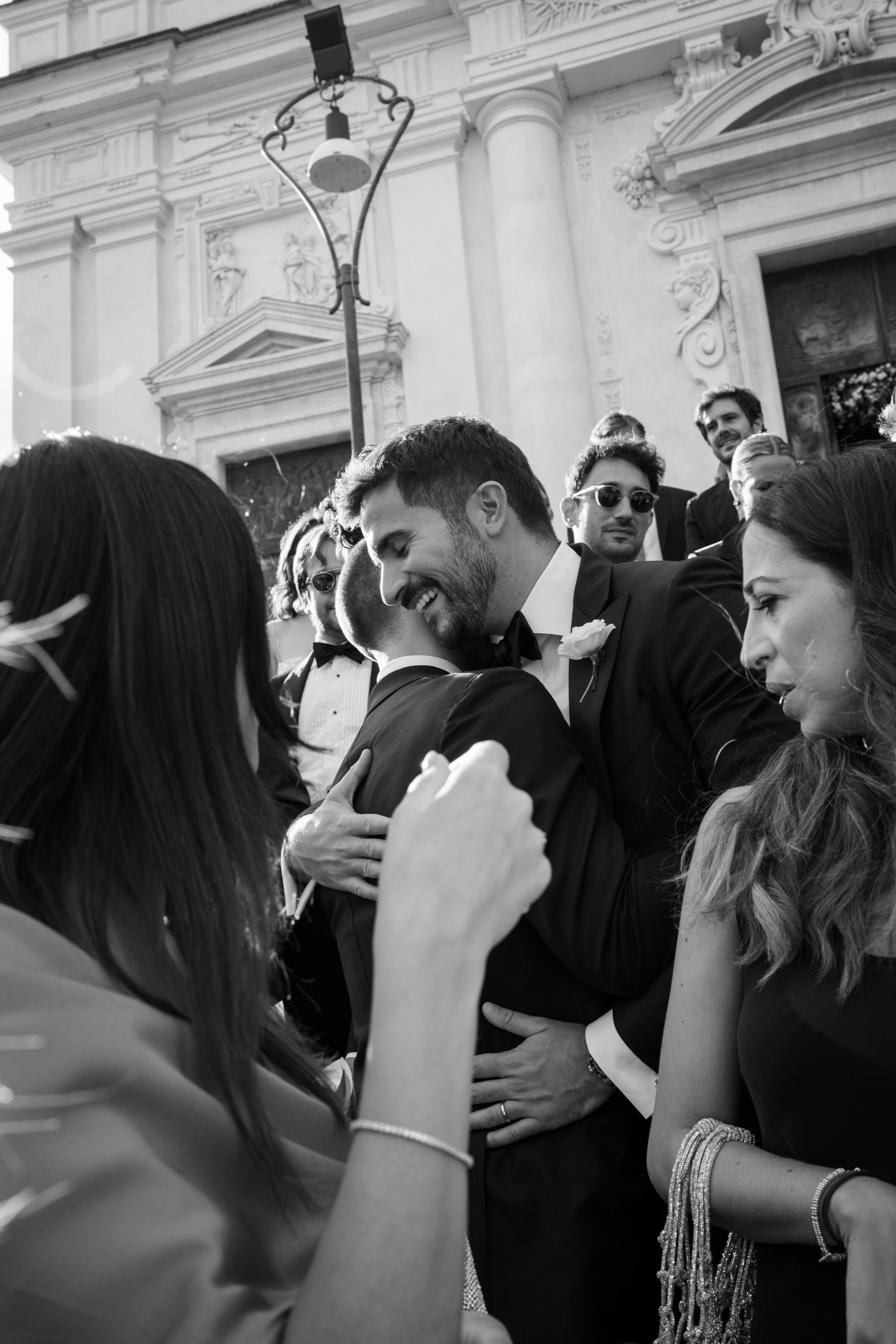 Elegant wedding in Portofino, with a view of the Ligurian bay, celebration at the historic Vesta Portofino by Dolce & Gabbana venue, capturing the atmosphere of the Dolce Vita and the Italian Riviera, groom smiling with guests at the end of the cerimny